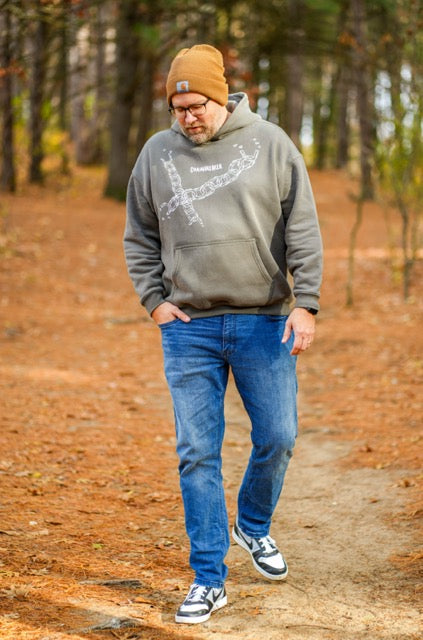 Man wearing a hoodie and jeans walking in a forest